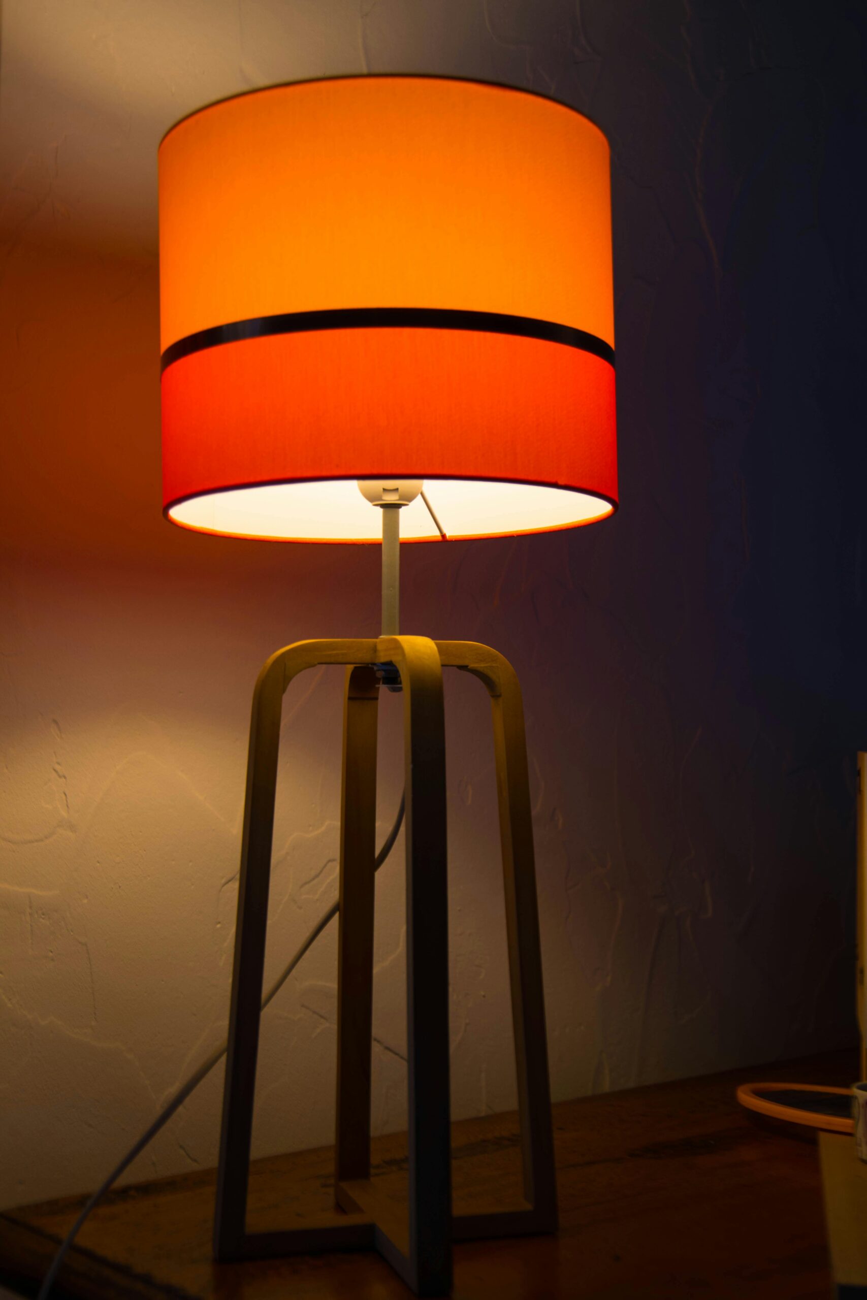 A stylish orange lamp providing warm ambiance in a modern bedroom setting.